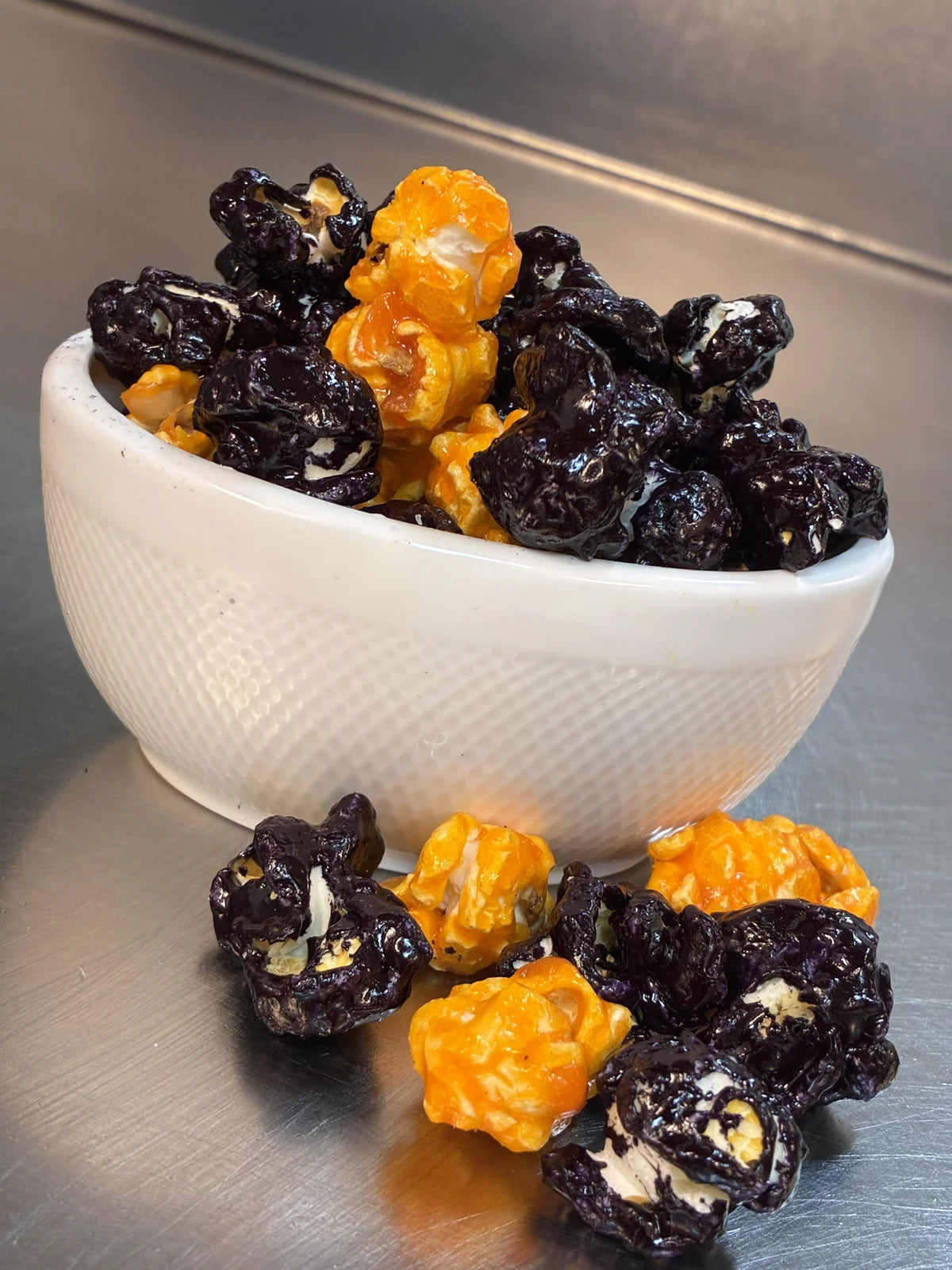 Bee-Witched black vanilla and orange candy popcorn in a white bowl